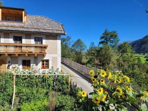 een huis met zonnebloemen aan de kant van een weg bij hoamisch Modern retreat in Malles Venosta