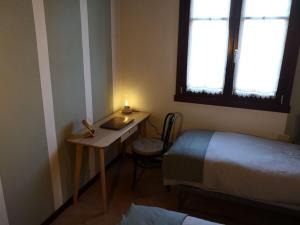 Cette petite chambre comprend un lit et un bureau avec une bougie. dans l'établissement Lugana Residence We LAKE it, à Peschiera del Garda