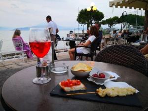 - une table avec un verre de vin et de nourriture dans l'établissement Lugana Residence We LAKE it, à Peschiera del Garda