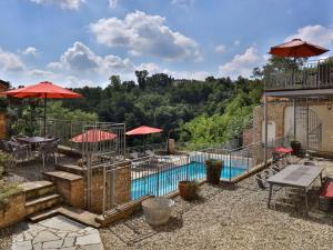 una piscina con mesas y sombrillas en un patio en Moscato Modern Retreat, en Mombaruzzo