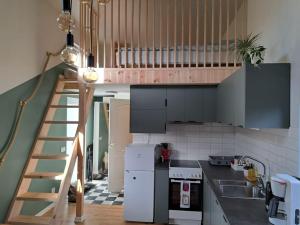 una cocina con una escalera que conduce a un loft en Attefallshus. en Västervik