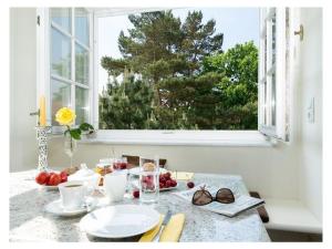 a table with plates of food and a window at "Seashell" Modern retreat in Binz +11 photos