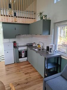 a small kitchen with a sink and a refrigerator at Attefallshus. in Västervik