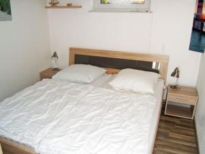 ein Schlafzimmer mit einem weißen Bett mit zwei Kissen in der Unterkunft "Seestrasse" 24 Merchant in Horumersiel