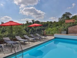een zwembad met stoelen en parasols op een patio bij Dolcetto at Villa Pesce in Mombaruzzo