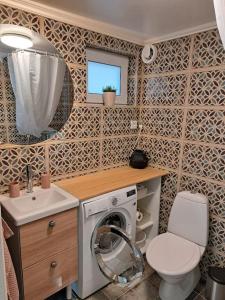 uma casa de banho com uma máquina de lavar roupa e um WC em Attefallshus. em Västervik