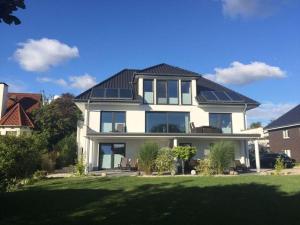 a large white house with solar panels on its roof at This year with lake view in Pönitz am See