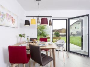 a dining room with a wooden table and red chairs at STAY4 2 Modern retreat in Wunsiedel