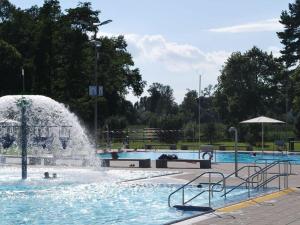 a fountain in a swimming pool with people in it at Säntis Modern retreat in Friedrichshafen