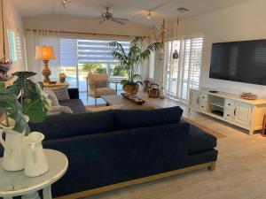 a living room with a blue couch and a tv at Villa Bayside Beach in Fort Myers Beach
