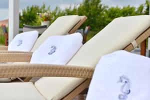 a row of wicker chairs with white pillows on them at Seepferdchen in Trent