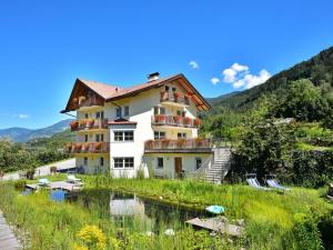 a building on a hill next to a river at Eisackblick Modern retreat in Brixen