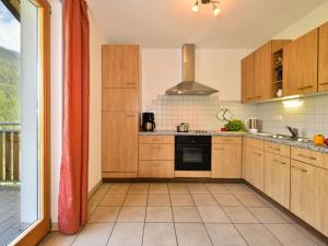 una cocina con armarios de madera y una gran ventana en Eisackblick Modern retreat en Brixen