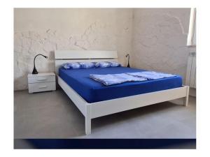 um quarto com uma cama com lençóis azuis e uma mesa de cabeceira em Villa del Maya Modern Retreat em San Pietro in Bevagna