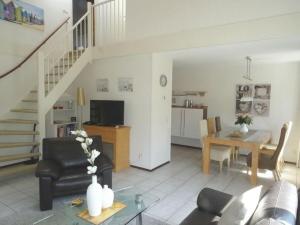 a living room with a table and a dining room at Summer Melody Comfortable holiday residence in Julianadorp