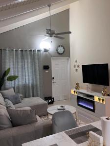 - un salon avec un canapé et un réveil sur le mur dans l'établissement Sky View Villas @ Edmund Ridge Estate, à Montego Bay