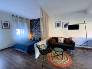 uma sala de estar com uma cama e um sofá em Studio d’hôtes avec piscine « Le Clos n°6 » em Cormicy