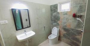 a bathroom with a sink and a toilet and a mirror at Kamlax Villa Near Serenity Beach at puducherry in Puducherry +11 photos