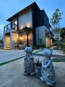 deux statues de chats debout devant une maison dans l'établissement D'Cove Villa Private Pool Kuantan, à Kuantan