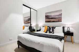 a bedroom with two beds and a desk at Blue Haven at Marvel Stadium - Rooftop Pool & Free Parking in Melbourne