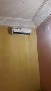a room with a yellow wall and a ceiling at Oluwa-Sheyi Apartment in Ketou in Kétou