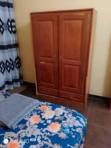 una camera con letto e armadio in legno di Oluwa-Sheyi Apartment in Ketou a Kétou