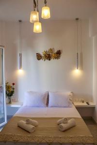 a bedroom with a bed with two towels on it at Aegean Pearl Studio in Tinos Town