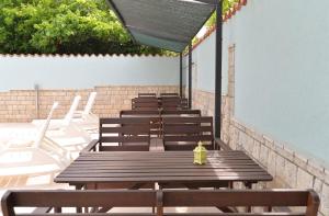 une rangée de tables en bois avec une bouche de feu jaune sur celle-ci dans l'établissement Ferienwohnung für 6 Personen ca 71 qm in Pula-Fondole, Istrien Istrische Riviera, à Štinjan