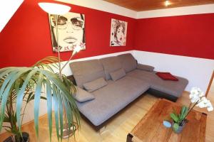 uma sala de estar com um sofá e paredes vermelhas em Ferienwohnung für 3 Personen 1 Kind ca 55 qm in Villingen-Rietheim, Schwarzwald em Villingen-Schwenningen