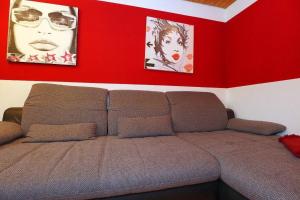 um sofá num quarto com duas fotografias na parede em Ferienwohnung für 3 Personen 1 Kind ca 55 qm in Villingen-Rietheim, Schwarzwald em Villingen-Schwenningen