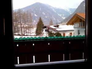 a view of a snowy mountain from a window at Ferienwohnung für 8 Personen ca 95 qm in Pellizzano, Trentino Val di Sole in Pellizzano