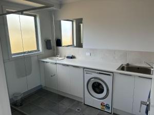 a kitchen with a washing machine and a sink at Ocean Yakka, Kangaroo Island in Penneshaw