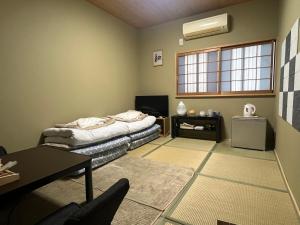大阪Wafu Ryokan Uehonmachi的带床和桌子的客厅