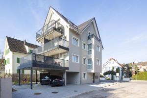 a house with a car parked in front of it at STAYY Flagship Limmattal - contactless check-in in Schlieren