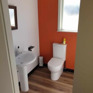 a bathroom with a toilet and a sink at 135 On Seaview Parpaparaumu Beach in Paraparaumu