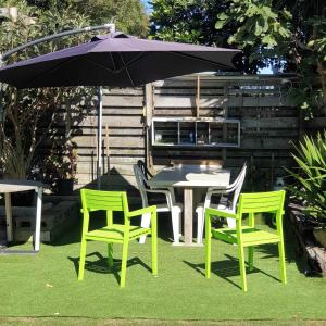 a table and chairs with an umbrella in a yard at 135 On Seaview Parpaparaumu Beach in Paraparaumu