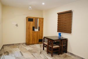 Zimmer mit einem Schreibtisch und einer Holztür in der Unterkunft Kalanad Residency in Kalanādu