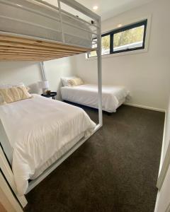 1 Schlafzimmer mit 2 Betten und einem Fenster in der Unterkunft Stunning Lakeside Villa in River Front Resort with Pool in Moama