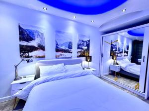 a bedroom with a large white bed and mountains at One Hyde Park by Wild London in London