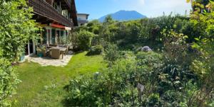 a garden in front of a house with a mountain at Haus Schmidhuber Wohnung 5 mit sonniger Terrasse in Grossgmain