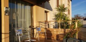2 Stühle und ein Tisch auf dem Balkon in der Unterkunft Bel Hotel in Saint-Nicolas-de-Redon