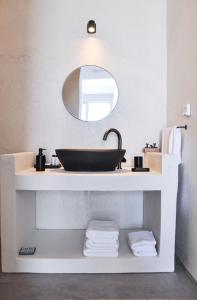 a bathroom with a sink and a mirror at Cave Suite in Sarakíniko