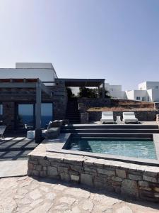 a swimming pool with two lounge chairs and a house at Cave Suite in Sarakíniko +14 photos