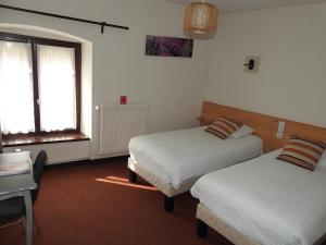 een hotelkamer met 2 bedden en een raam bij Le Barriol in Saint-Julien-Chapteuil