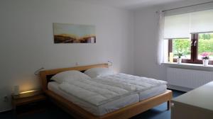 Bett in einem weißen Zimmer mit Fenster in der Unterkunft Ferienwohnung für 4 Personen ca 103 m in Kiel, Ostseeküste Deutschland Kieler Bucht in Kiel