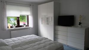 Schlafzimmer mit einem Bett und einem Flachbild-TV in der Unterkunft Ferienwohnung für 4 Personen ca 103 m in Kiel, Ostseeküste Deutschland Kieler Bucht in Kiel