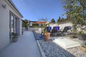 a backyard with a patio with chairs and an umbrella at Ferienhaus mit Privatpool für 8 Personen ca 80 qm in Ližnjan, Istrien Südküste von Istrien in Ližnjan +14 photos