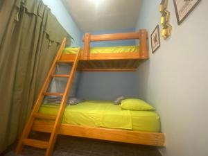 Ce lit superposé se trouve dans un dortoir avec une échelle. dans l'établissement Volcano Pines Retreat, à Alto Boquete