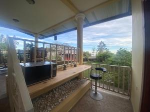 una veranda protetta con una televisione e uno sgabello di Volcano Pines Retreat ad Alto Boquete Altre 15 foto