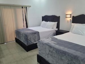 Yamaranguila的住宿－Hotel Victoria Inn，酒店客房设有两张床和窗户。